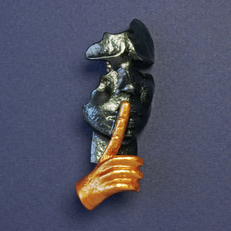 Brooch 'Mask' with dark gray and yellow enamel, gold-tone metal, 52x20 mm