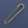 Brooch pin with white rhinestones 72x16 mm ± gold-toned metal