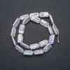 Thread of natural Baroque pearls, diameter 18x10 mm, length 39 cm +/- with gasoline iridescence