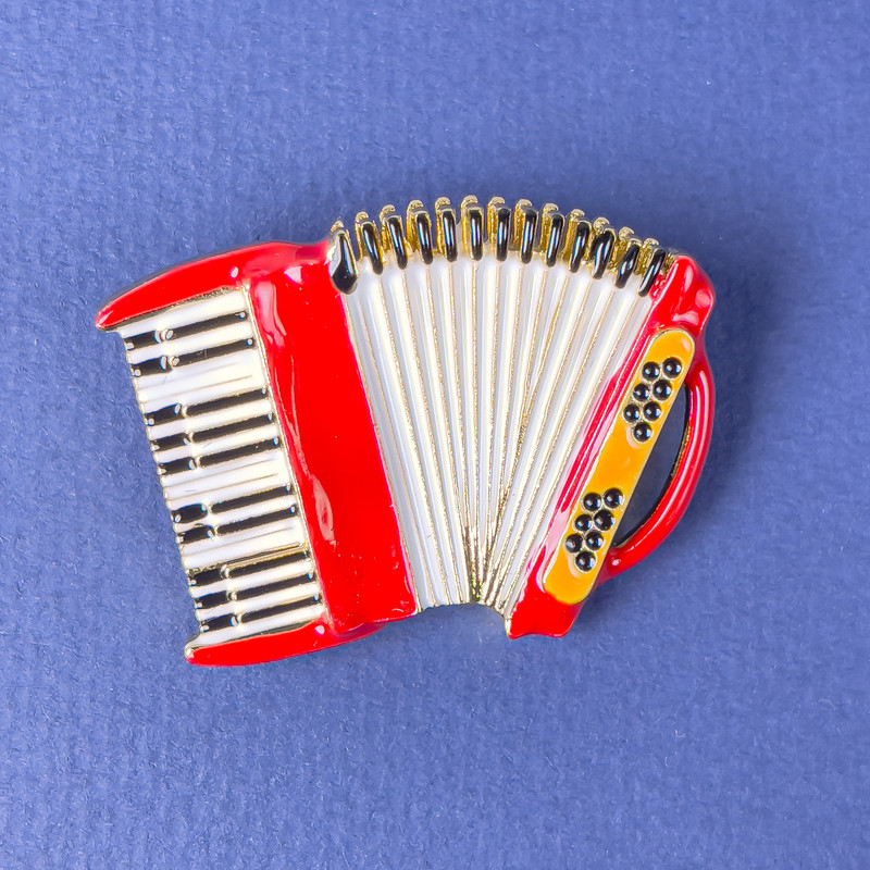 Brooch 'Accordion' red, white and black enamel on golden metal 42×31 mm+